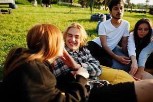 Young multi ethnic group of people watching movie at poof in open air cinema. photo