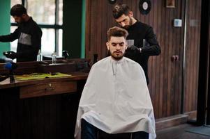 Handsome bearded man at the barbershop, barber at work. photo