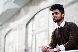 Portrait of young stylish indian man model pose in street. photo