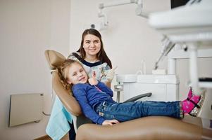 Little baby girl at dentist chair. Children dental. photo