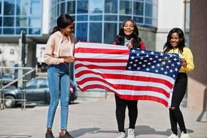 Three young college african american womans friends with flag of USA. photo