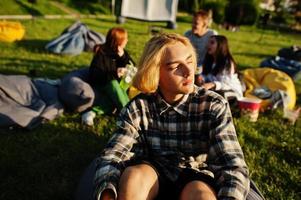 Young multi ethnic group of people watching movie at poof in open air cinema. Close up portrait of funny guy. photo