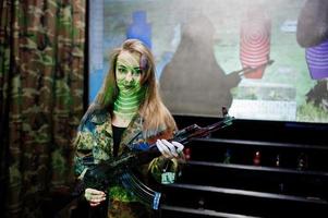 Girl with machine gun at hands on shooting range. photo