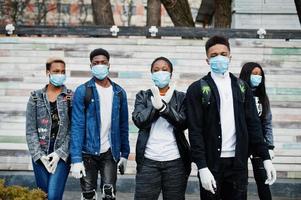 grupo de amigos adolescentes africanos que usan máscaras médicas protegen de infecciones y enfermedades cuarentena del virus del coronavirus. foto