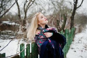 Blonde girl with hand embroidered scarf posed at winter day. Women's handkerchief. photo