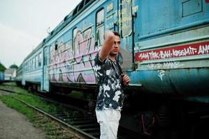 retrato de estilo de vida de un hombre guapo con mochila posando en la estación de tren. foto