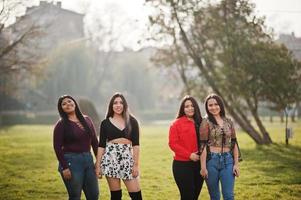 Group of four happy and pretty latino girls from Ecuador posed at street. photo