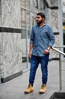 Stylish indian beard model man in casual clothes posed outdoor at street of India. photo