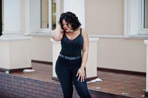 Stylish african american plus size model at streets of city on winter day. photo