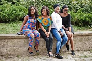 Group of four african american girls sitting outdoor. photo