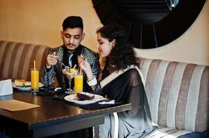 Lovely indian couple in love, wear at saree and elegant suit, posed on restaurant. photo