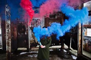 Young girl with blue and red colored smoke bomb in hands. photo