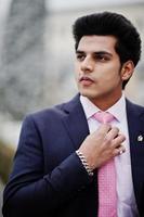 Elegant indian macho man model on suit and pink tie posed on winter day. photo