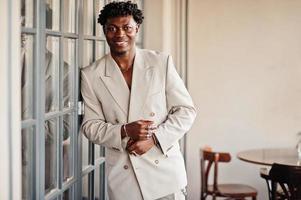 Stylish afro man in beige old school suit. Fashionable young African male in casual jacket on bare torso. photo