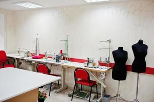 lugar de trabajo de la oficina de costurera con máquina de coser en la mesa. foto