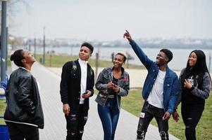 jóvenes amigos africanos de la generación del milenio caminando en la ciudad. gente negra feliz divirtiéndose juntos. concepto de amistad de generación z. foto