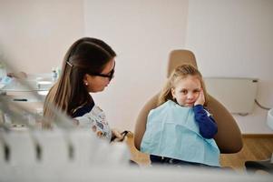 Little baby girl at dentist chair. Children dental. photo