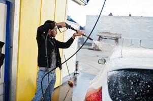 hombre del sur de asia o hombre indio lavando su transporte blanco en el lavado de autos. foto