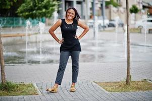 Young african american woman posed against fountain. photo