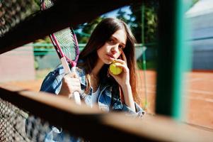 Young sporty girl player with tennis racket on tennis court. photo