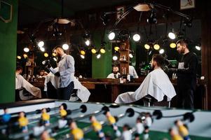 apuesto hombre barbudo en la barbería, peluquero en el trabajo. foto