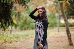 retrato de una joven y hermosa adolescente india o del sur de asia vestida en un parque de otoño en europa. foto