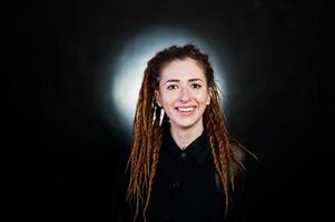 Studio shoot of girl in black with dreads at black background with nimbus. photo