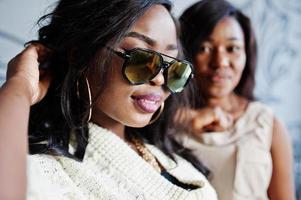 Close up of two stylish african american girls in sunglasses. photo