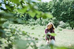 Close-up portrait of a smiling blond girl in tartan shirt in the countryside. photo