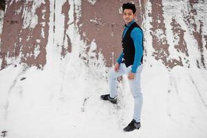 Casual young indian man in blue shirt and black waistcoat posed at winter day. photo