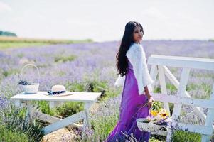 hermosa niña india usa vestido tradicional saree india en campo de lavanda púrpura. foto