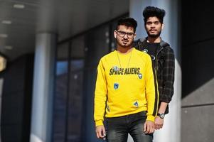 Two asian guys posed against new modern building. photo