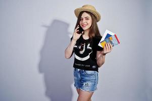 Girl tourist with warszawa map, wear in lol shirt, shorts and hat with mobile phone isolated on white. photo