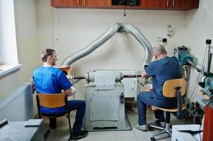 dos trabajadores protésicos que fabrican una pierna protésica mientras trabajan en el laboratorio. foto