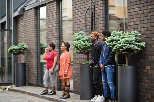 Four african friends having fun outdoors. Two black girls with guys. photo