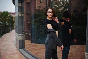 A tall leggy young beautiful and elegant model woman. Business woman at eyeglasses. photo