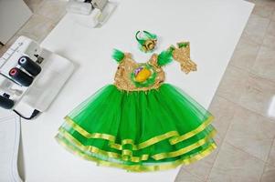 disfraz de niña hecho a mano de carnaval infantil en la oficina de costurera en el lugar de trabajo. foto