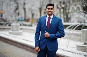 elegante modelo de hombre de moda indio en traje posado en el día de invierno. foto