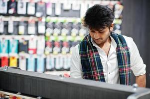 Indian man customer buyer at mobile phone store choose a case for his smartphone. South asian peoples and technologies concept. Cellphone shop. photo