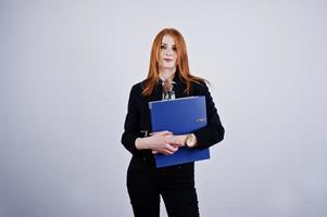 retrato de una mujer de negocios pelirroja con blusa a rayas y una chaqueta con una carpeta azul. foto