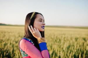 Tender indian girl in saree, with violet lips make up posed at field in sunset. Fashionable india model. photo