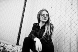 Young hipster girl in checkered shirt posed outdoor. photo