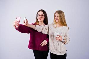 dos chicas con vestidos morados tomándose selfie en el estudio. foto