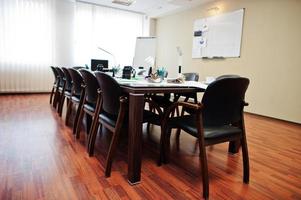 Modern business office interior containing tables and chairs, laptop, camera and office supplies with no employees. photo