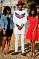 grupo de tres elegantes amigos de moda afro francia posaron en el día de otoño. modelo de hombre africano negro con dos mujeres de piel oscura. foto