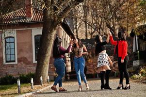 Group of four happy and pretty latino girls from Ecuador posed at street. photo