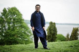 Stylish pakistani indian muslim arabic man in kurta dhoti suit and sunglasses. photo