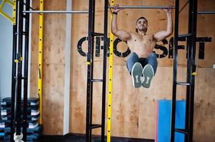 Fit and muscular arabian man doing workouts in gym. photo