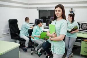 Medical theme .Portrait of female doctor with clipboard against group of doctors meeting in the mri office at diagnostic center in hospital. photo