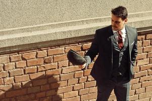 retrato de un hombre de negocios árabe inglés retro de los años 20 con traje oscuro, corbata y gorra plana. foto